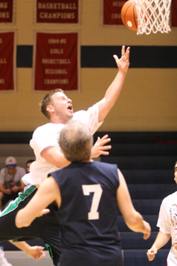 Competitors reached for the goal of raising funds for an alcohol and drug awareness program during an April 16 basketball game that matched staff members from Roncalli High School in Indianapolis against doctors from St. Francis Hospital & Health Centers. Brian Lauck, an assistant coach for the Roncalli football team, swoops toward the basket in the Docs vs. Jocks vs. Drugs game. (Submitted photo)