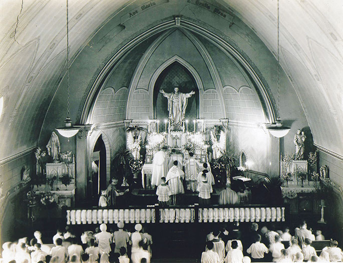 This photograph was taken at an event honoring senior citizens at St. Gabriel Parish in Connersville in May 1981. Following Mass said by Archbishop Edward T. O’Meara, several priests served dinner to 300 seniors in attendance. The priests are, from left to right, Fathers Harold Knueven, Stephen Jarrell, Glenn O’Connor, Robert Mazzola, and Archbishop O’Meara. Seated in front of the priests are Mistress of Ceremonies Karolyn Buckler and Elizabeth Mazzola, the mother of Father Mazzola, who made the archbishop’s apron. This photo originally appeared in the Connersville News Examiner.