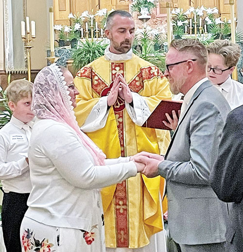 Father Dustin Boehm, pastor of St. Gabriel Parish in Connersville, convalidates the marriage of Larissa and Jason Cullen as their sons Andrew, right, and Aiden, left, look on after the Easter Vigil Mass at St. Gabriel Church in Connersville on March 31. (Submitted photo)