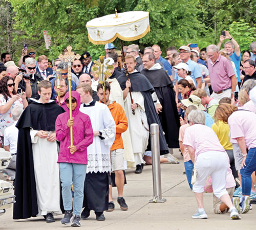 People start to take to their knees in Christ’s presence at the base of a ramp to the Louisville, Ky., side of the Big Four Bridge over the Ohio River as a eucharistic procession to Jeffersonville gets under way on July 9, marking the entrance of the National Eucharistic Pilgrimage’s southern route into the Archdiocese of Indianapolis. (Photo by Natalie Hoefer)