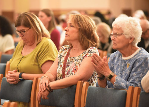 Women kneel in prayer during a Mass of Thanksgiving for the National Eucharistic Congress on Sept. 18. (Photo by Sean Gallagher)