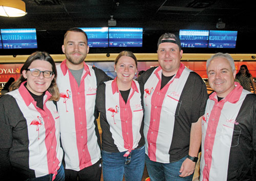 The smiles and the flamingo-designed bowling shirts that connect teammates Emily Mastronicola, left, Jeffrey Brown, Rachel Gilman, Kyle Ginty and Mike O’Connell are striking examples of the fun and joy that marked the IndyCatholic’s young adult bowling league this fall. (Photo by John Shaughnessy)