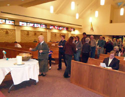 Sister Joan Hastreiter, a Sister of St. Joseph, and Sacred Heart parishioners place names of those inactive Catholics they are praying for in the prayer bowl during the Lenten Mission. The theme for the mission was “Falling in Love with God” and Wednesday night’s speaker, Msgr. Bernard Galic, pastor of St. Aloysius, Yoder, spoke on faith in God. 